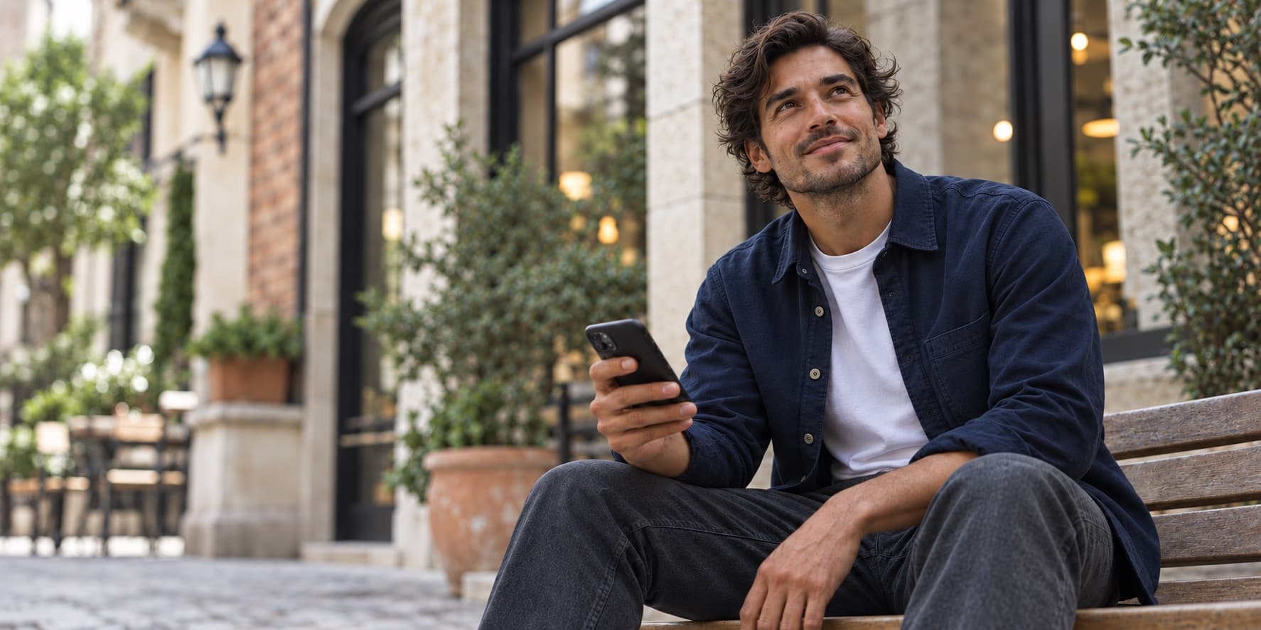 Ondernemer op een bankje die op zijn telefoon kijkt wat een AI-assistent aanraadt